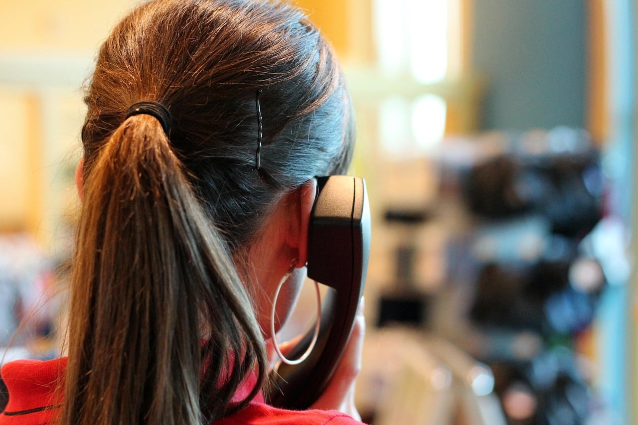 Operatrice di call center vista da dietro mentre parla al telefono, concetto di assistenza clienti e gestione del turnover.